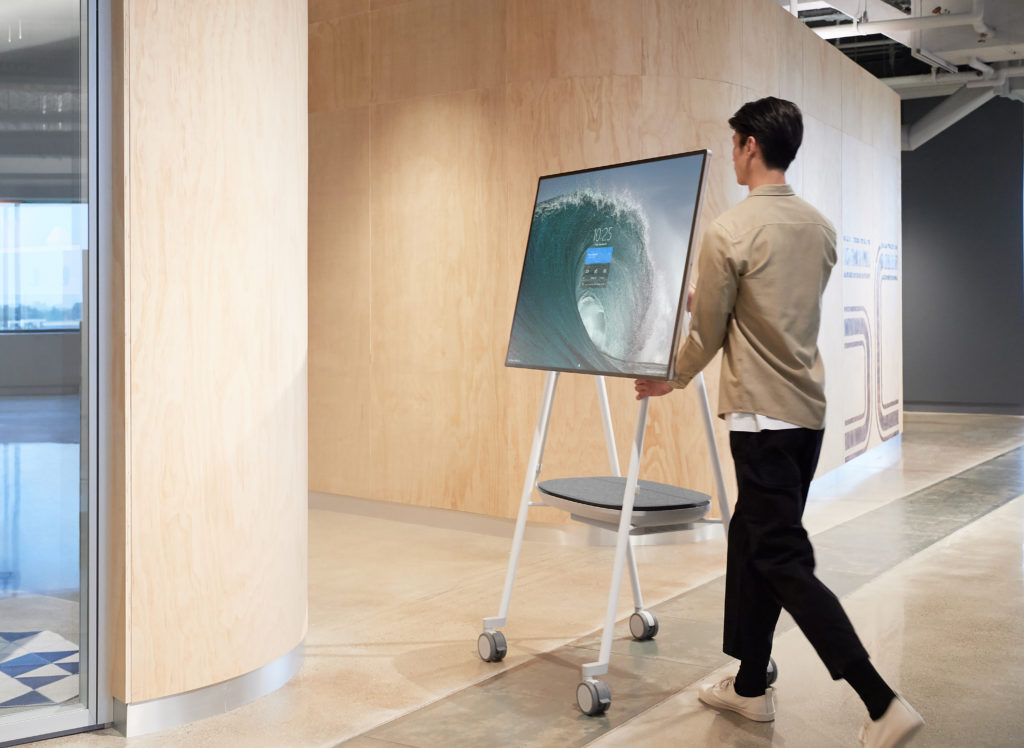 Person moves Microsoft Surface Hub 3 between corporate conference rooms.